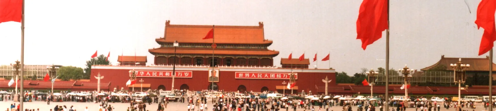 Tiananmen Gate with red flags above visitors in central Beijing