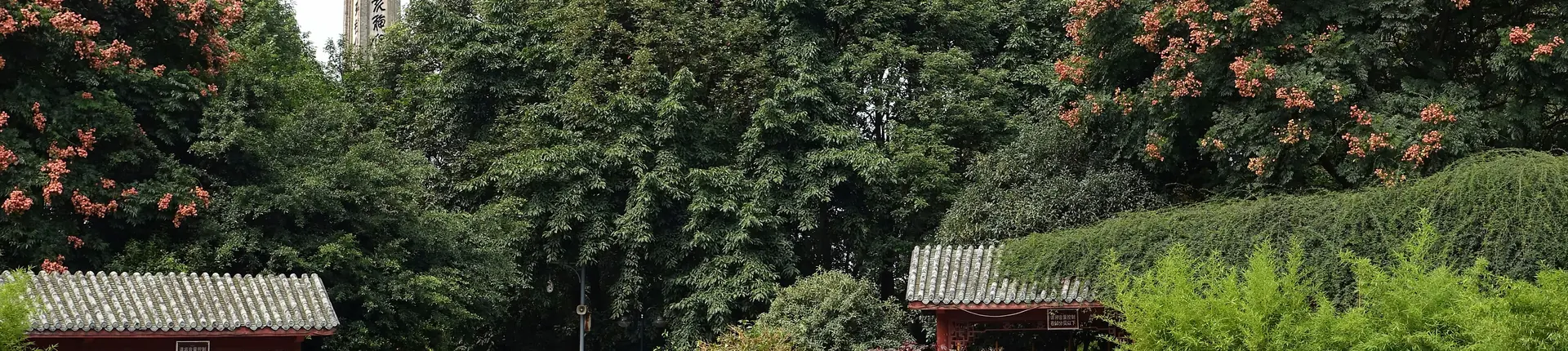 Traditional tiled gateways and pavilions among leafy park trees