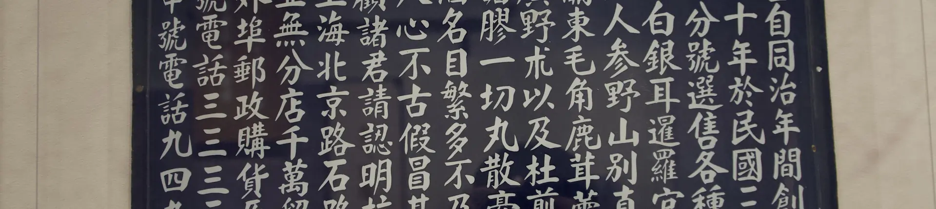 White Chinese calligraphy written in rows on a dark board