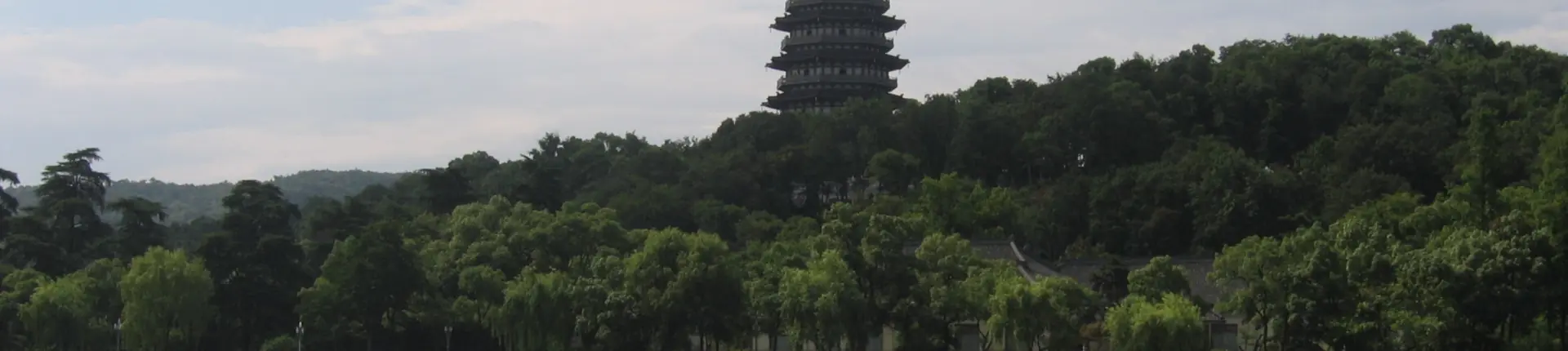 Tiered Leifeng Pagoda rising above wooded hills beside West Lake in Hangzhou