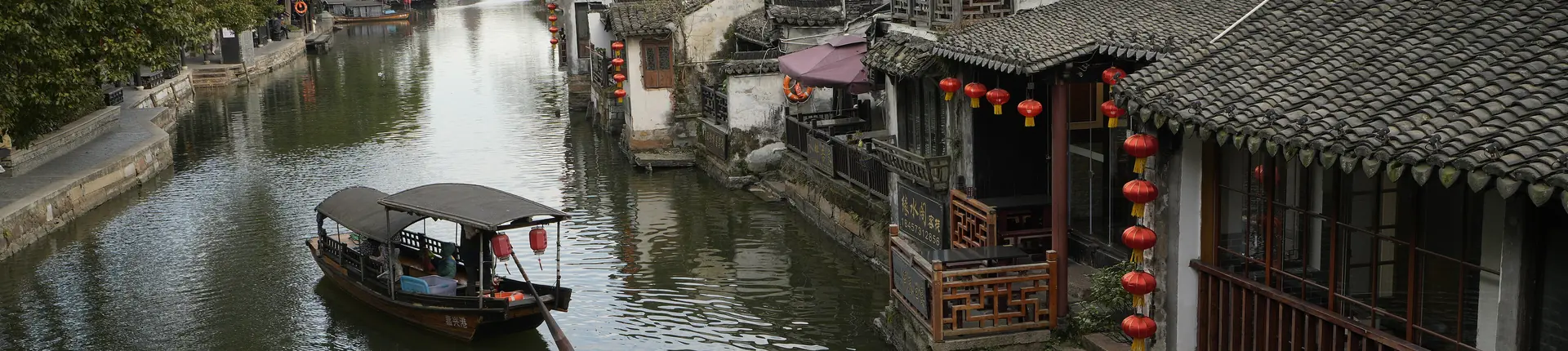 Wooden canal-side houses and a moored boat in Xitang Water Town, Zhejiang