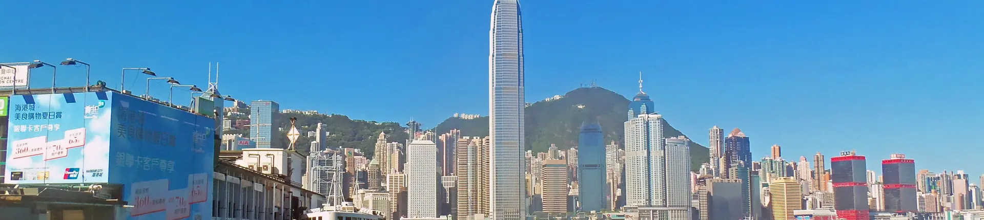 Tall waterfront office towers against a blue sky on Hong Kong Island