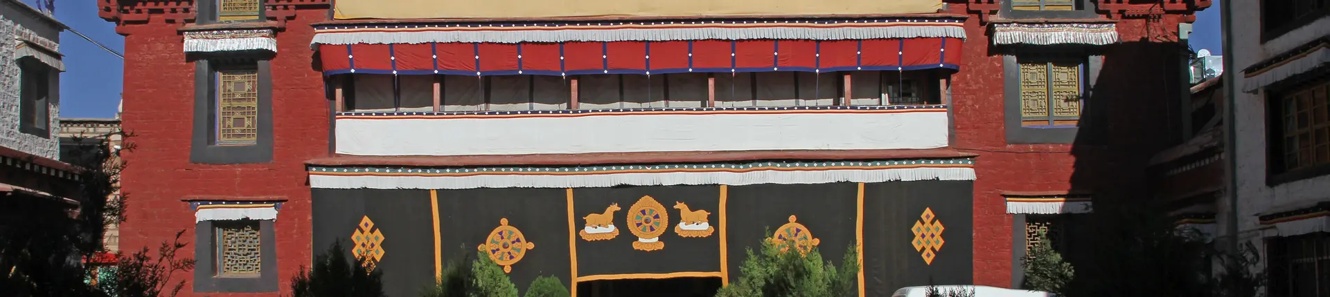Red temple facade and gold decorative panels at Ramoche Monastery in Lhasa