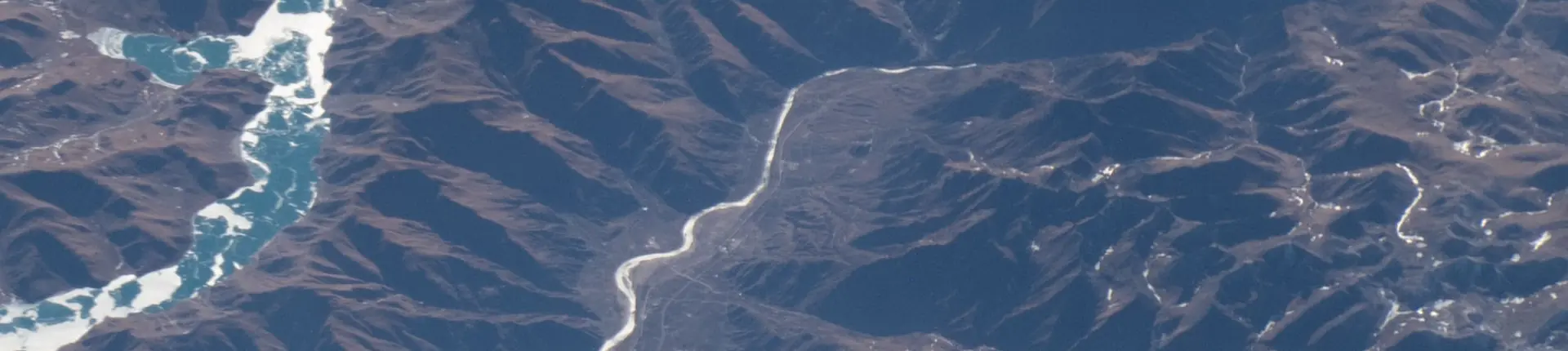 Aerial view of winding roads and blue inlets around Yamdrok Lake, Tibet