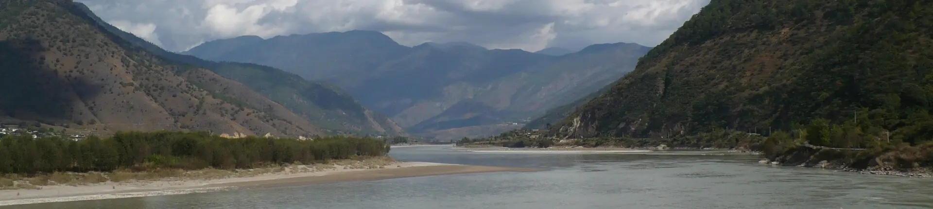 Saluran sungai yang luas di antara tebing berhutan dan rabung gunung di hulu Sungai Yangtze