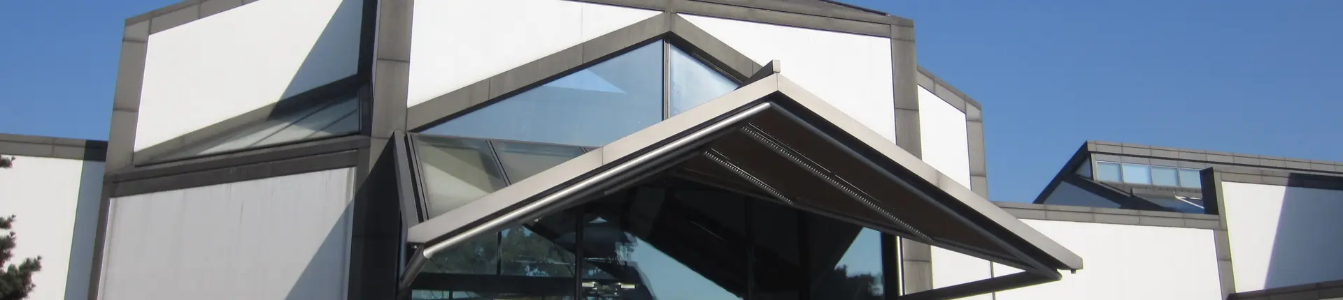 White museum walls with angular black rooflines and glass panels at Suzhou Museum