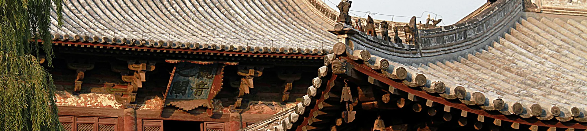 Curved tiled eaves and ornate wooden brackets at Dule Temple in Tianjin