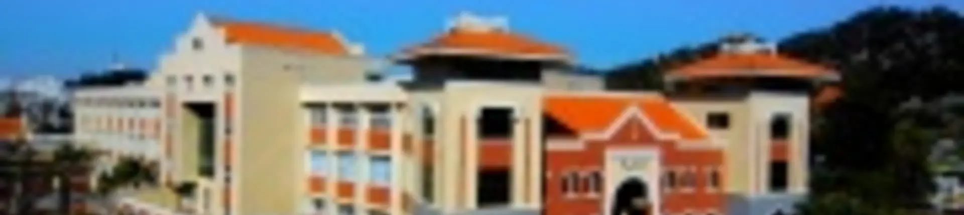 Campus building with orange tiled roofs, cream walls and columns at Xiamen University