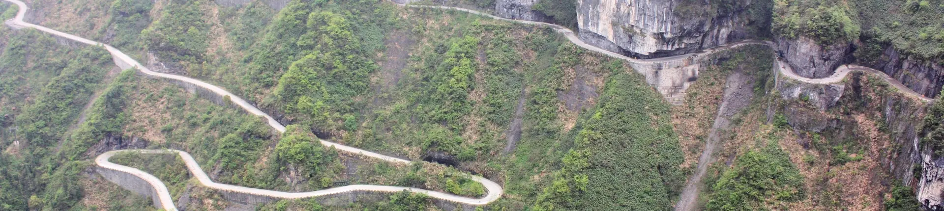 Winding mountain road climbing wooded cliffs on Tianmen Mountain near Zhangjiajie