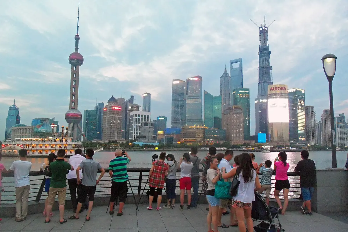 Visitors photograph Shanghai's Lujiazui skyline from the Bund waterfront