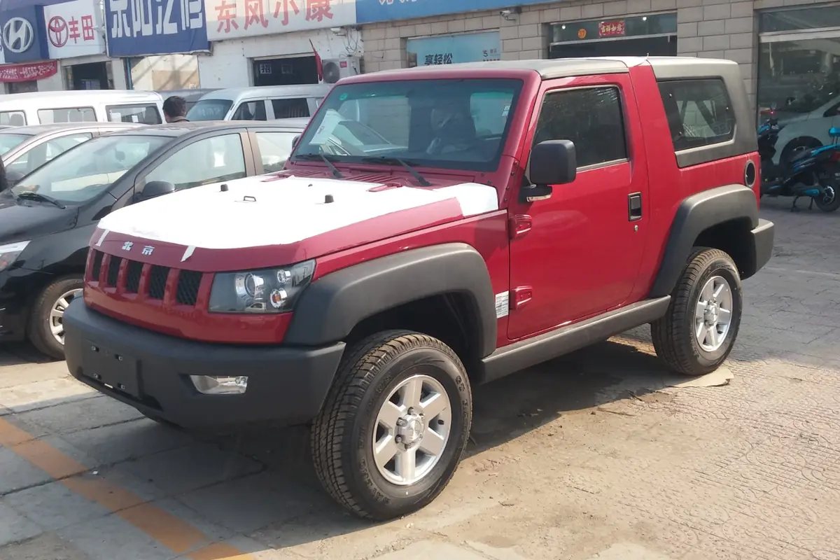 Red-and-white SUV parked outside a dealership beside other vehicles