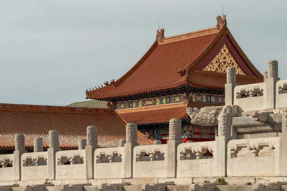 Golden-roofed Forbidden City palace hall behind carved white stone balustrades in Beijing