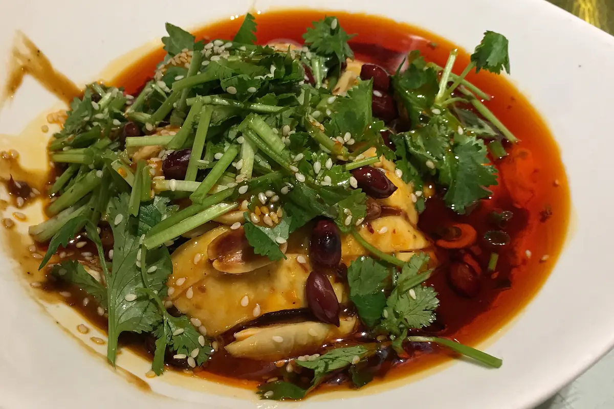 Chicken in red chili sauce topped with a generous layer of fresh cilantro
