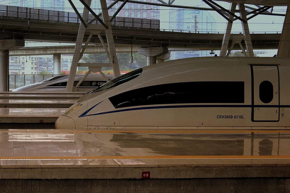 White high-speed trainsets parked along platforms at Shanghai South Railway Station