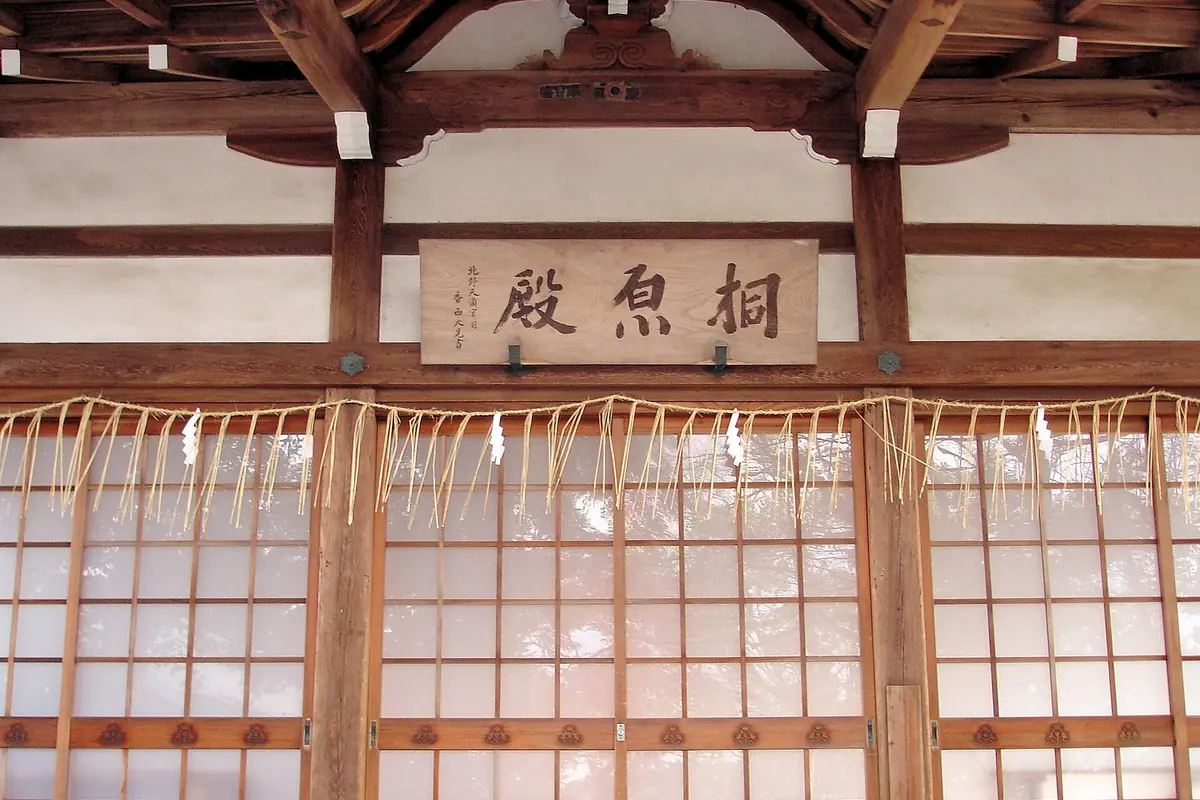 Wooden tea-house entrance with paper screens and a Chinese calligraphy sign