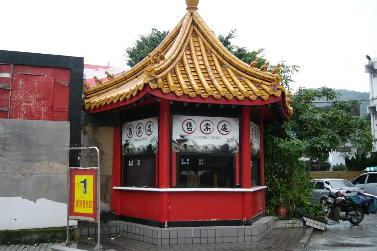 Red ticket kiosk with a golden tiled roof and decorative eaves