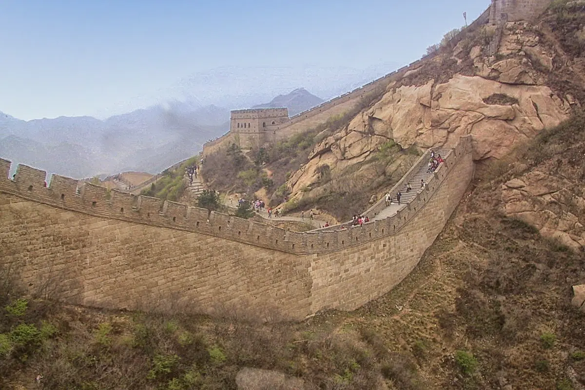 Great Wall ramparts curving across bare rocky hills and distant mountains