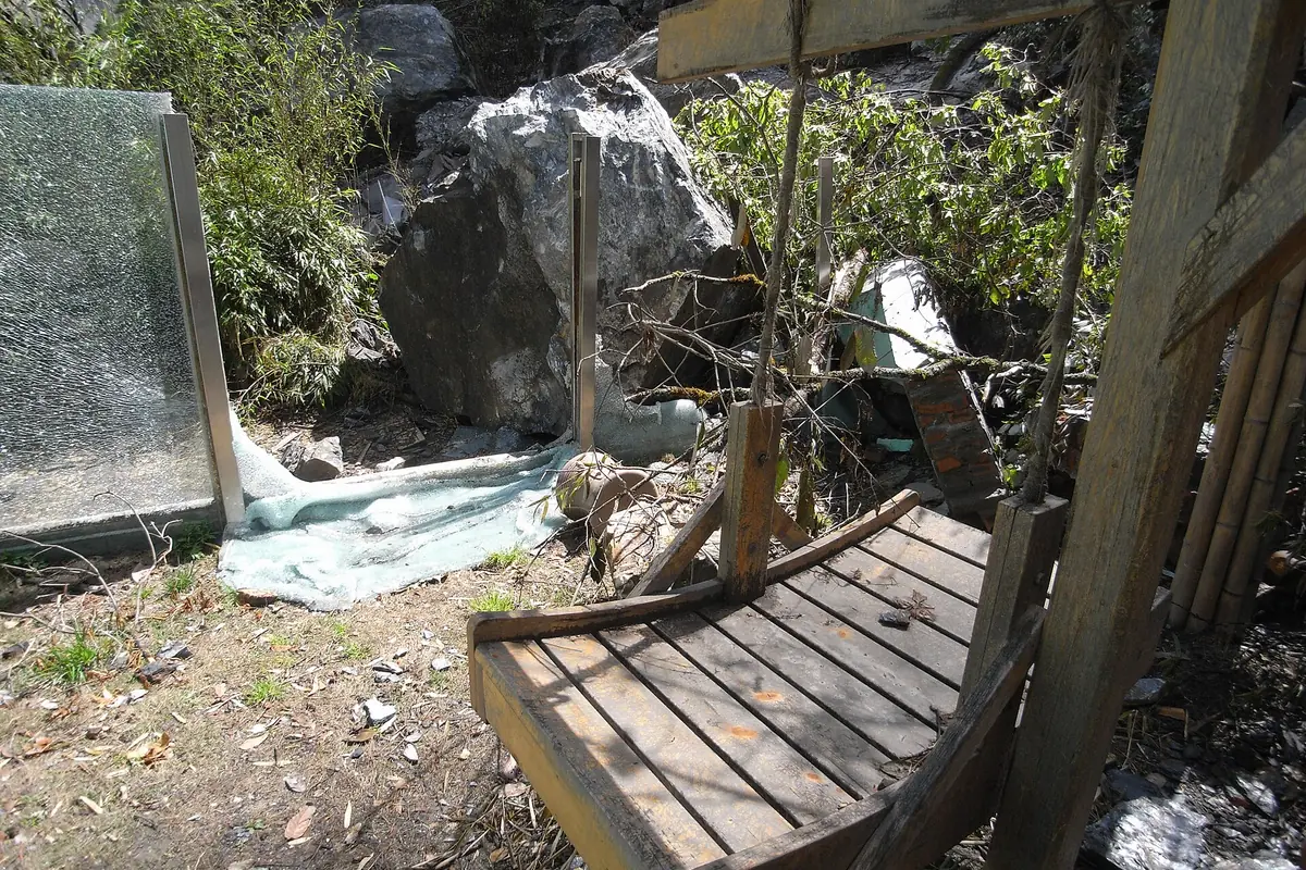 Wooden platform beside a rocky stream and green trees