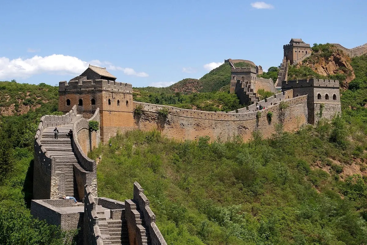 Great Wall watchtowers and stone steps across dry green-and-brown hills