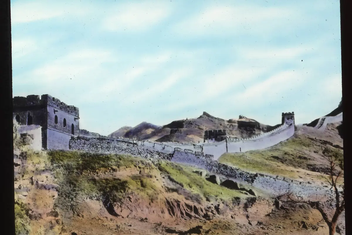 Weathered Great Wall sections and ruined towers across a grassy hillside