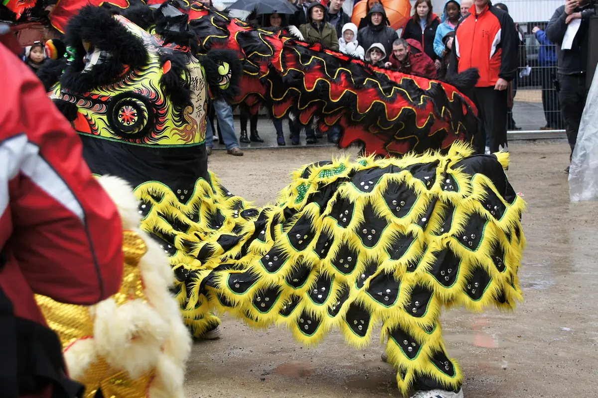 Colorful lion-dance costumes among performers and spectators during a Chinese New Year celebration