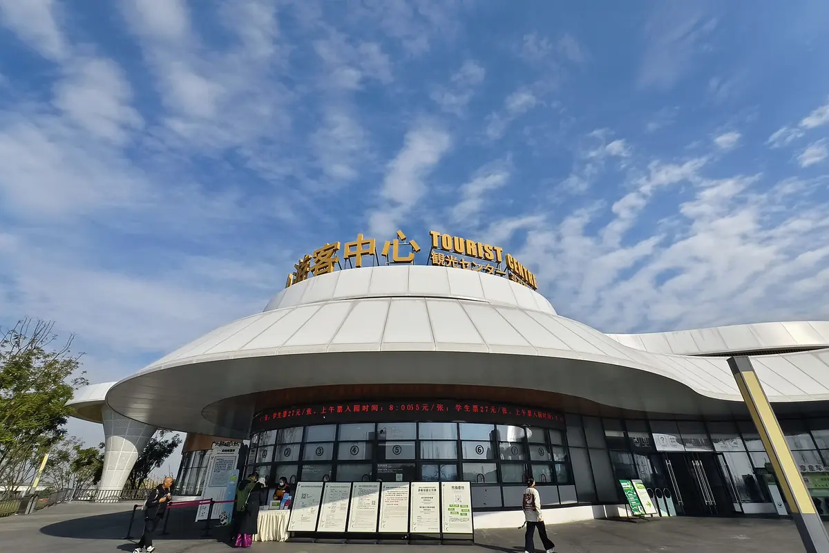 Round tourism-center entrance beneath a domed roof and blue sky