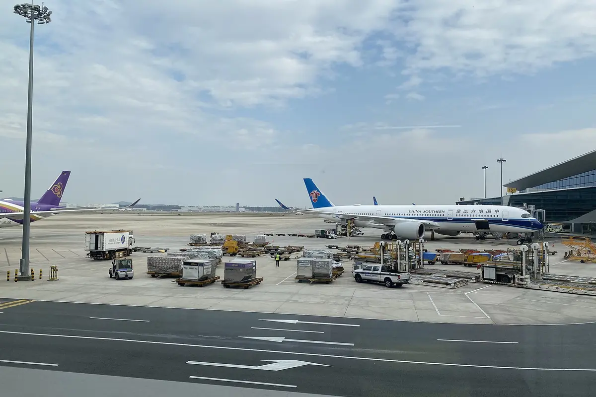 Passenger aircraft and baggage vehicles on the apron at Guangzhou Baiyun Airport