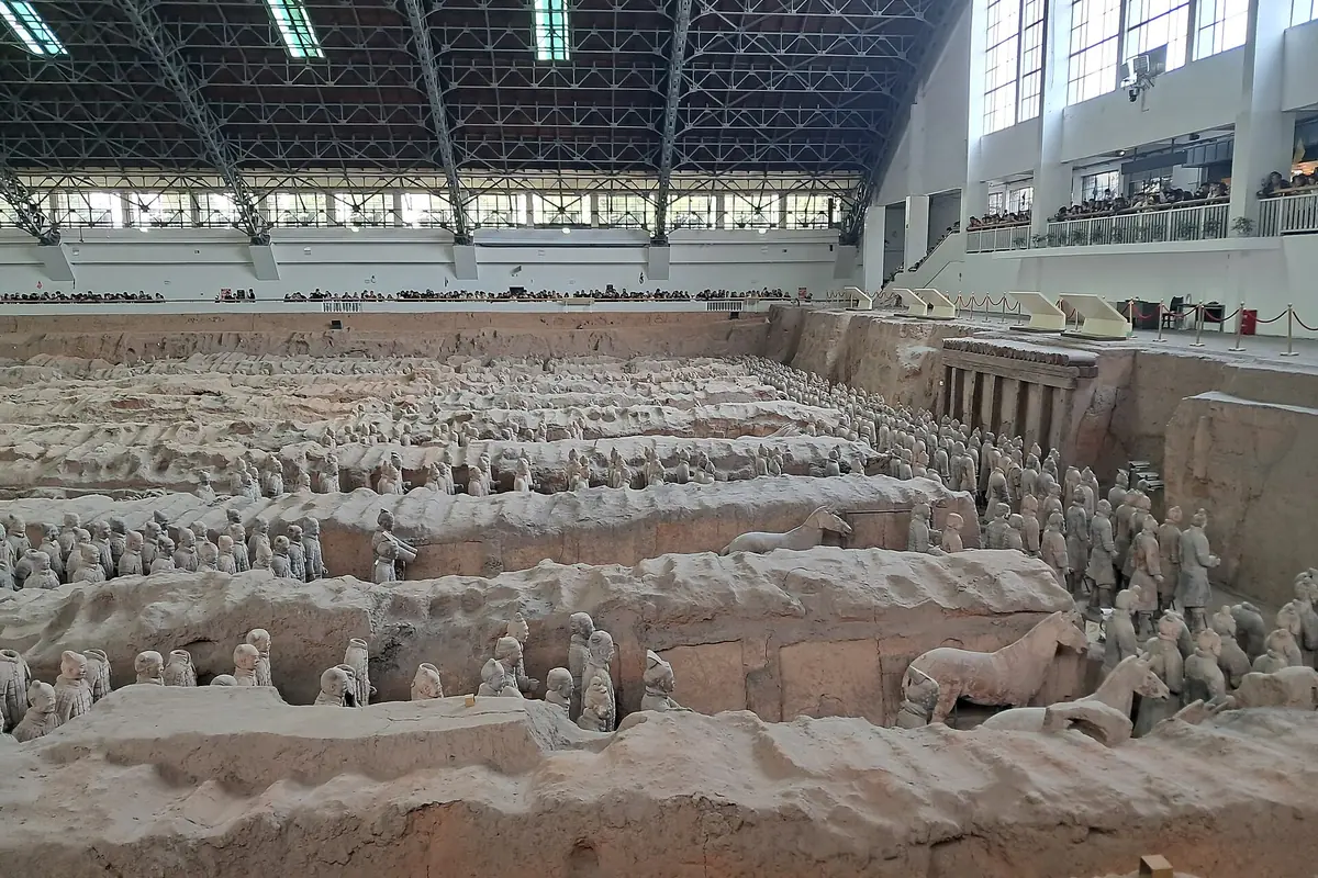 Excavated rows of Terracotta Warriors beneath the steel roof of a museum hall near Xi'an