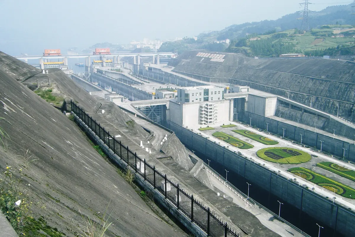 Long concrete dam and large riverside buildings at the Three Gorges Dam on the Yangtze River
