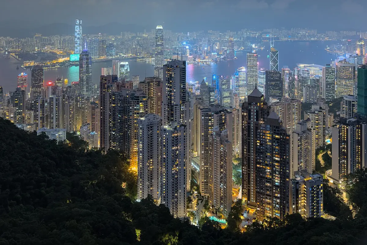 Hong Kong's densely packed high-rise buildings illuminated above Victoria Harbour at night