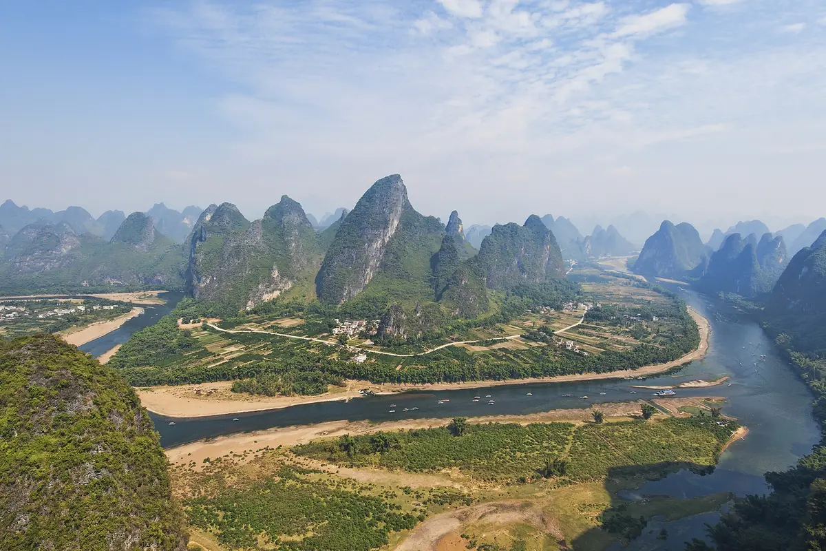 River winding between karst peaks and fields near Guilin