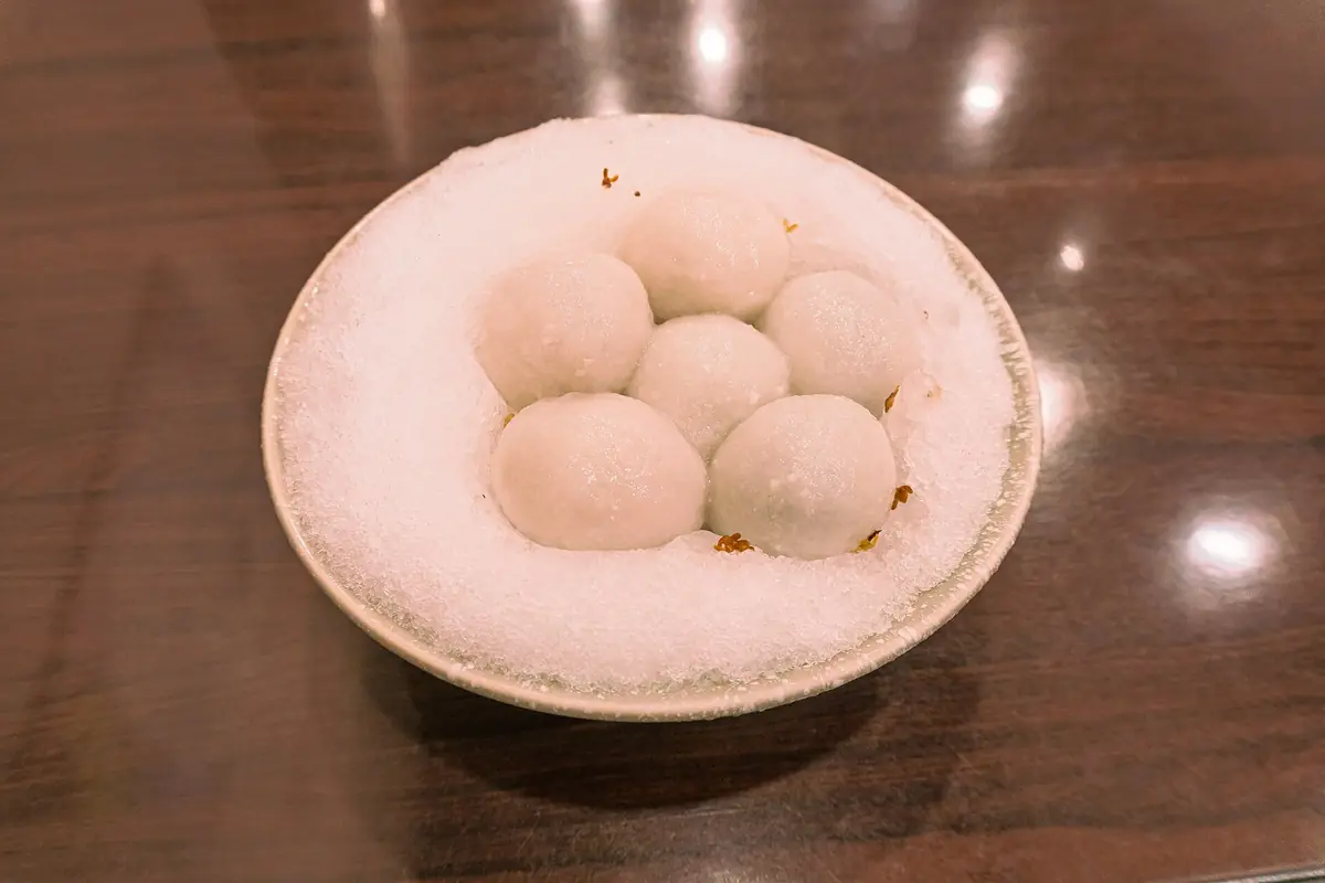 White tangyuan rice balls in a bowl of shaved ice on a table in Taipei