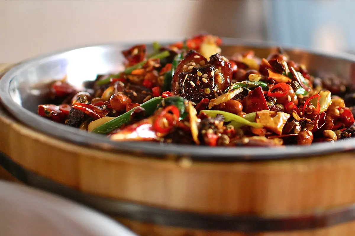 Chili-covered stir-fried meat served in a round metal bowl