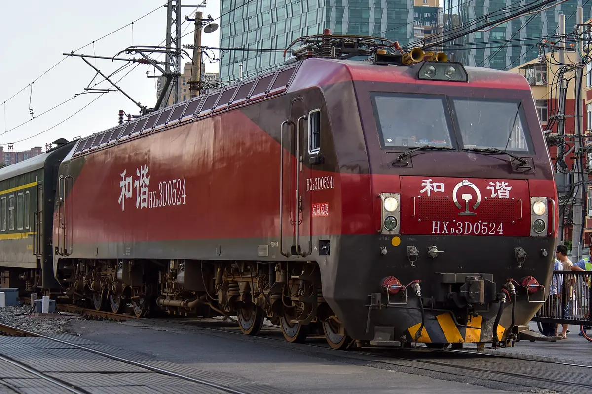 Red electric freight locomotive beneath overhead railway wires