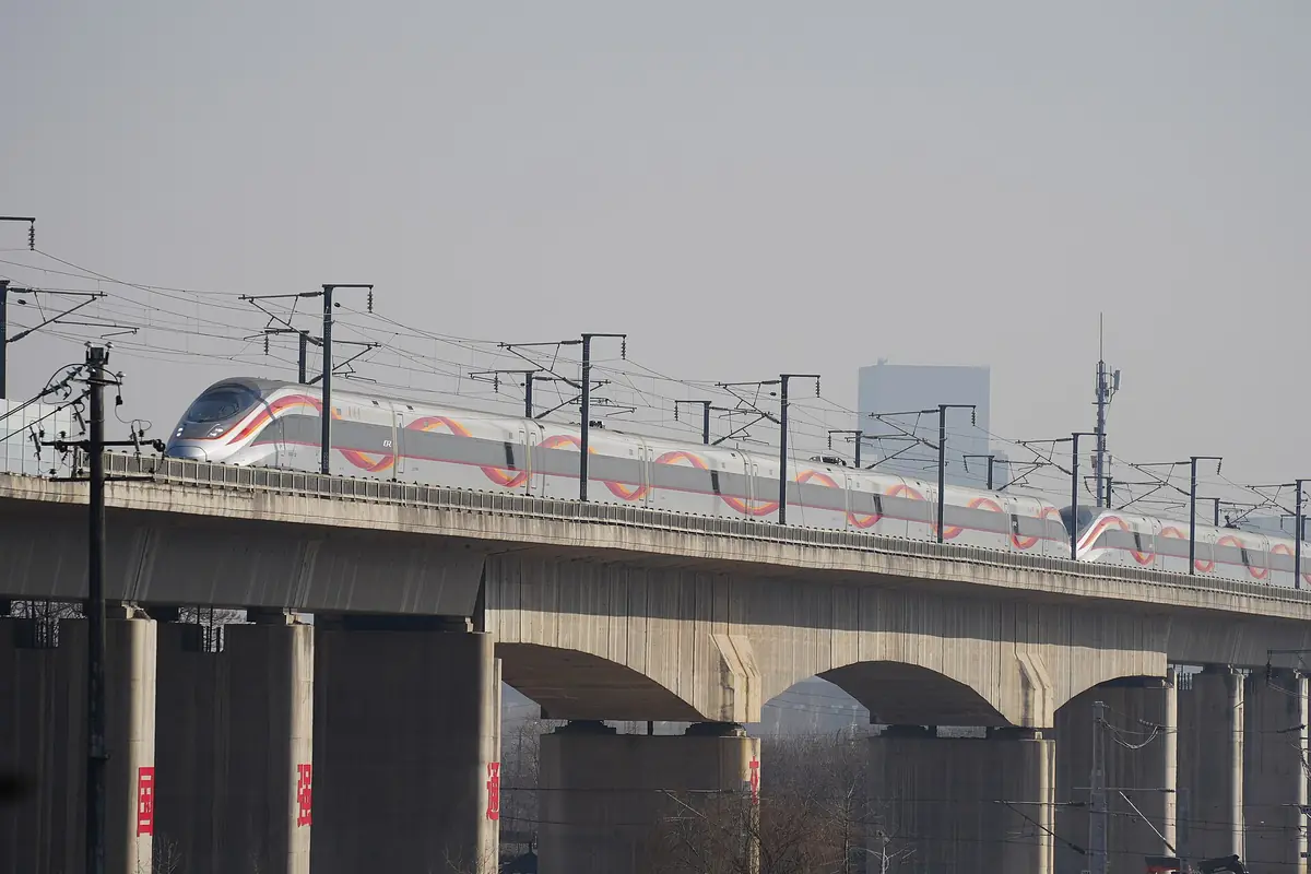 High-speed train crossing an elevated concrete railway viaduct