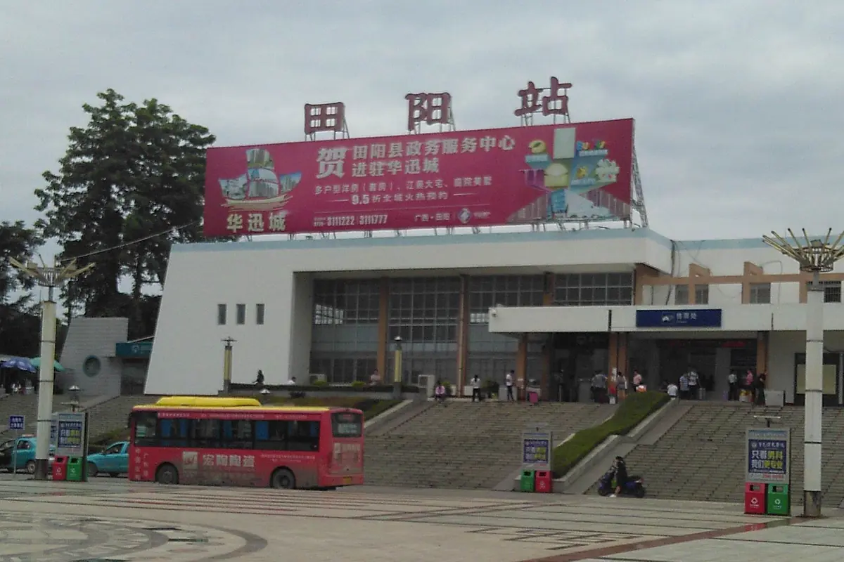 Shaoyang Railway Station entrance with Chinese signage and a red bus outside