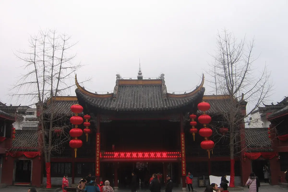 Traditional temple entrance framed by red lanterns and leafless trees