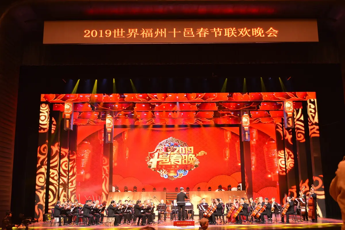 Performers on a red festival stage beneath a gold-lettered Chinese banner
