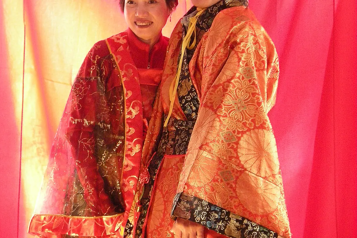 Red-and-gold ceremonial robes with patterned sleeves displayed indoors