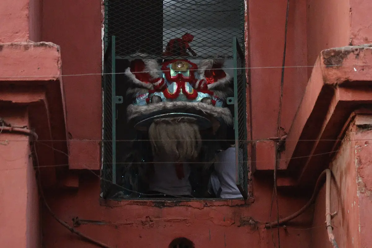 Small window in a red wall with an ornamental red-and-white painted panel