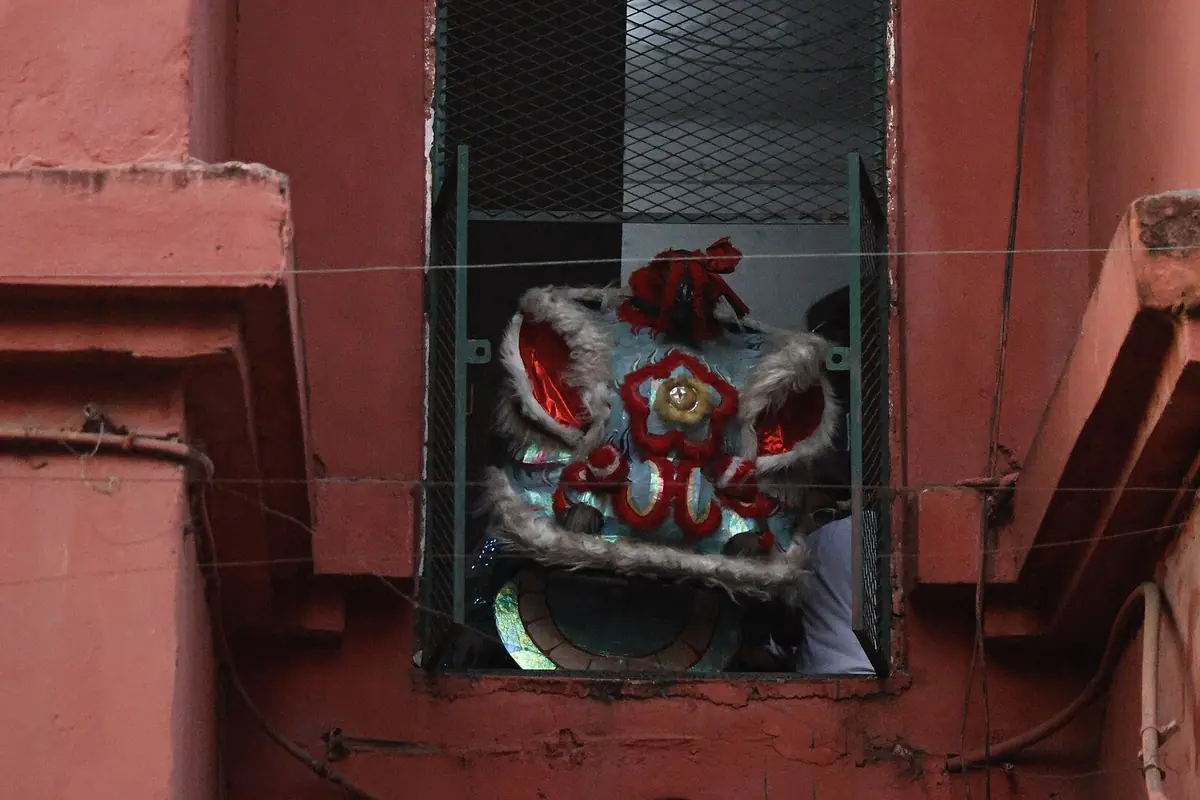 Rot-weiße Ziertafel in einem kleinen Fenster einer roten Wand