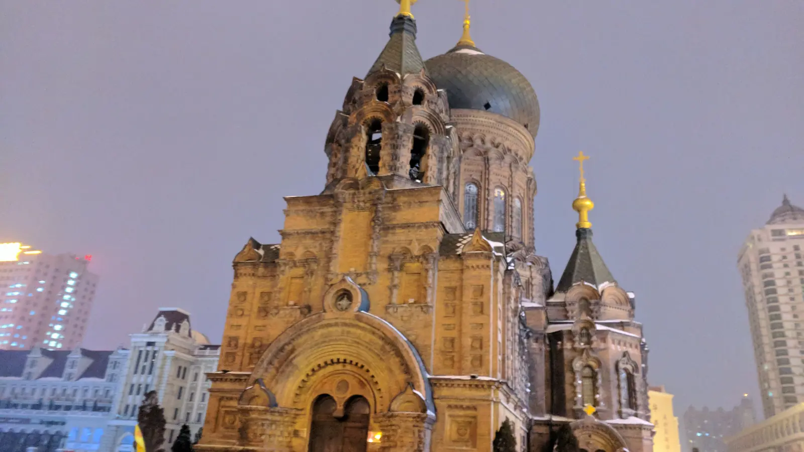 Brick towers and domed roofs of Saint Sophia Cathedral in Harbin under a gray sky