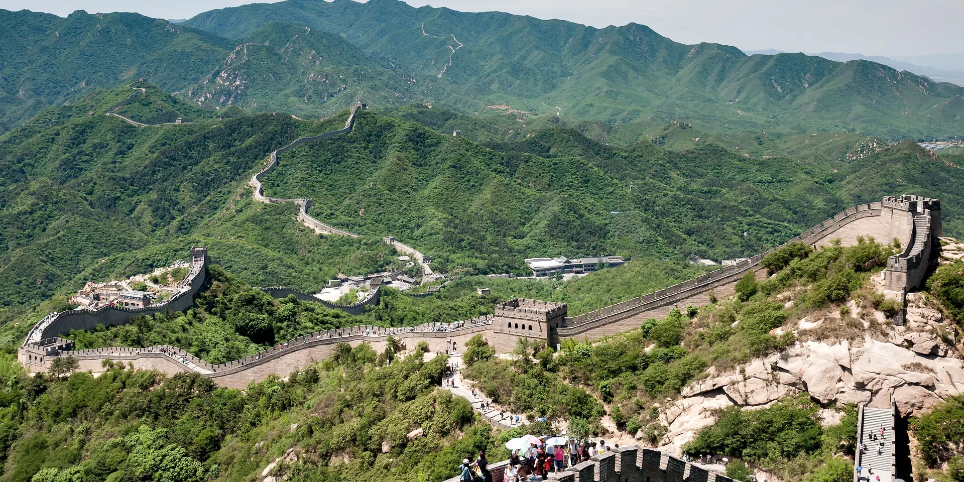 Great Wall of China winding across green mountain ridges