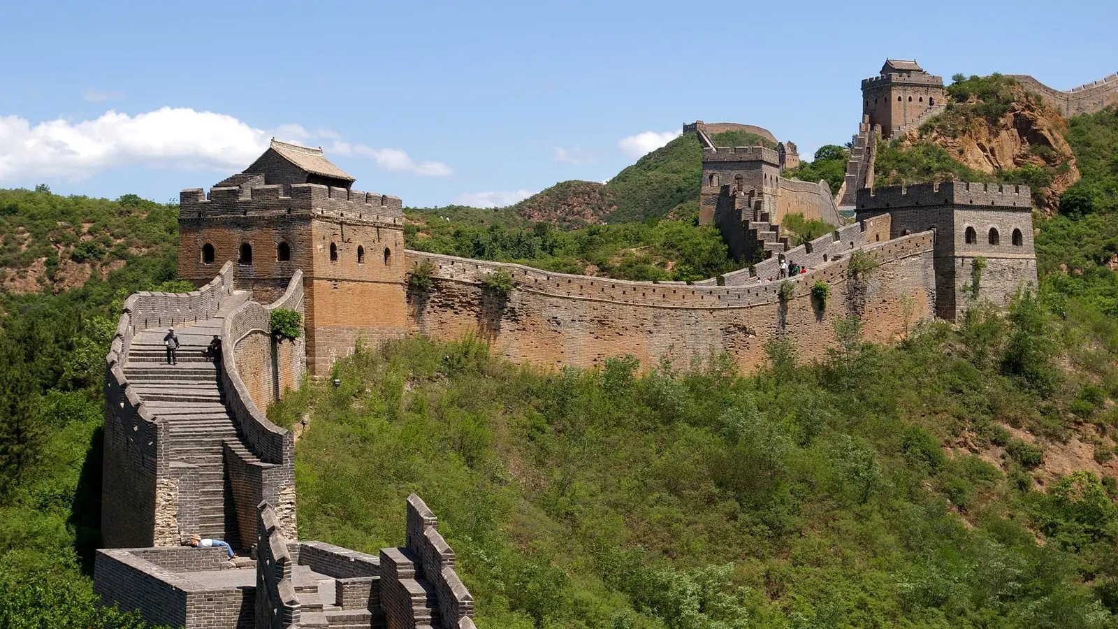 Stone watchtowers and crenellated walls following mountain ridges on the Great Wall of China