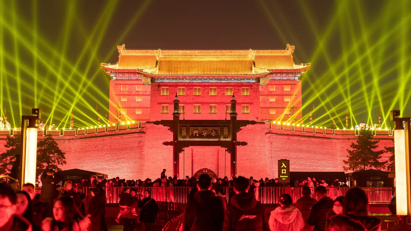 Xi'an city gate illuminated in red and gold above an evening crowd