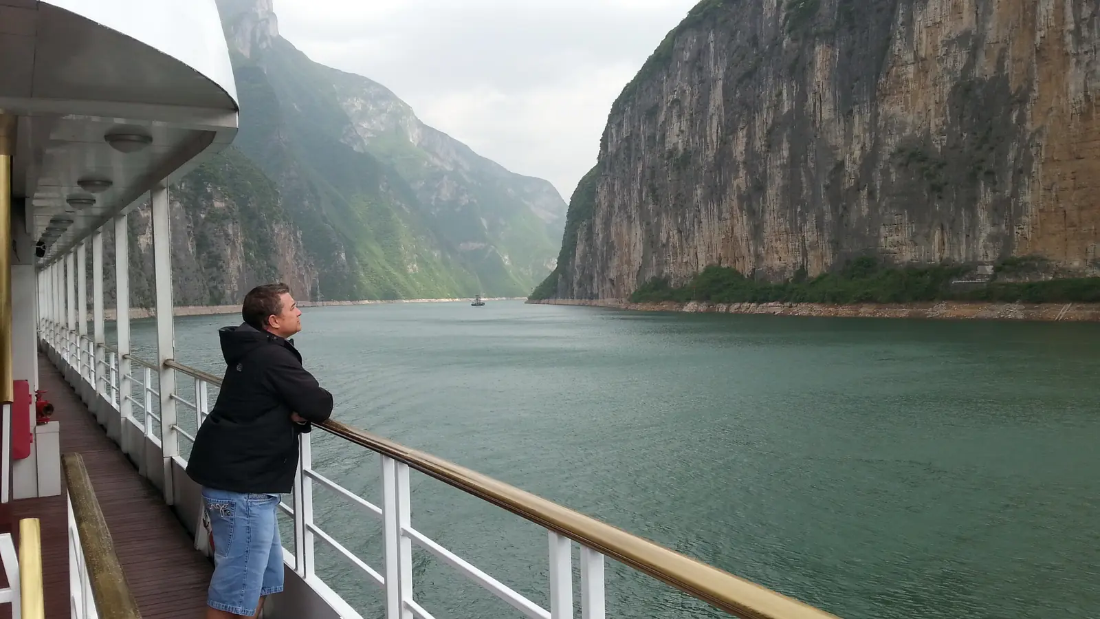 Cruise passenger looking across the Yangtze River between steep rocky cliffs