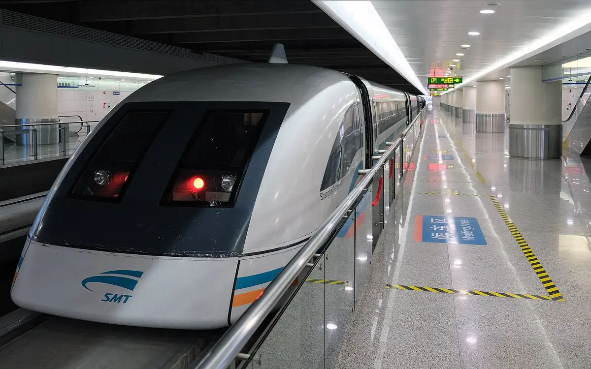 Shanghai maglev train beside a bright platform with glass barriers