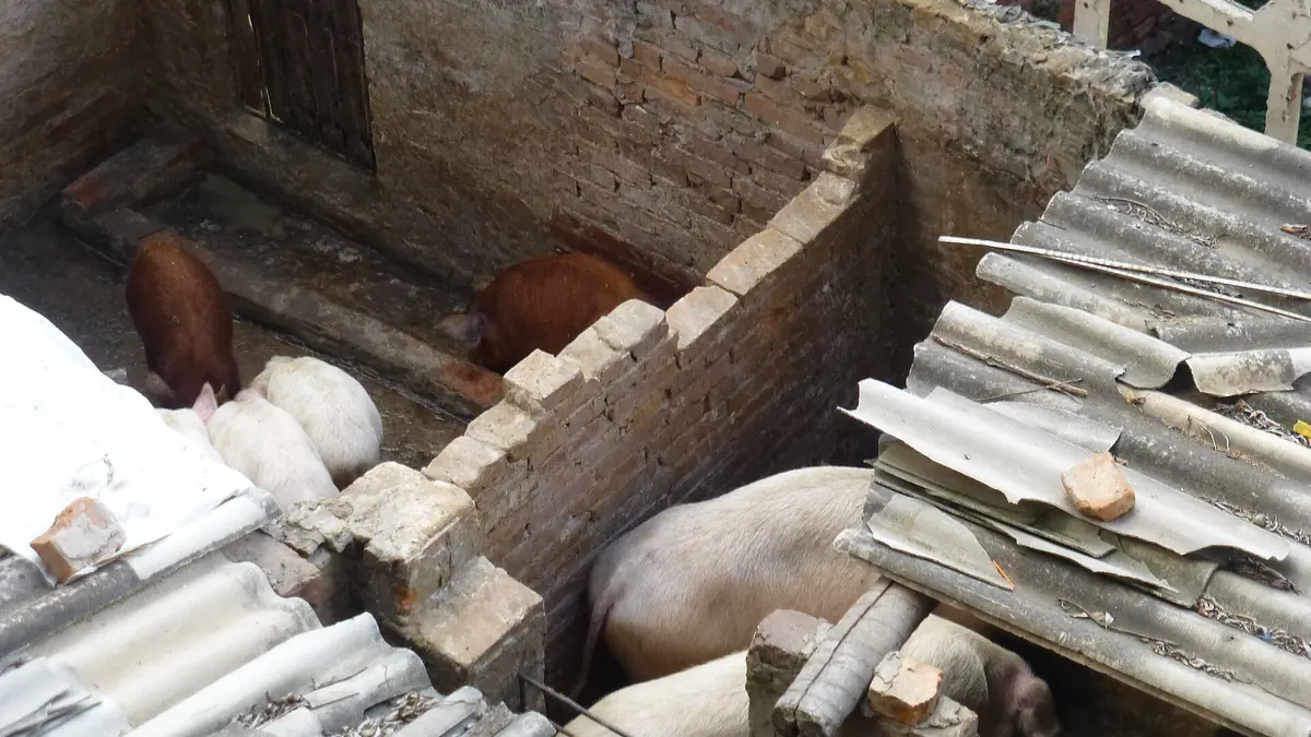 Broken curved roof tiles beside a brick kiln and an earthen workshop floor
