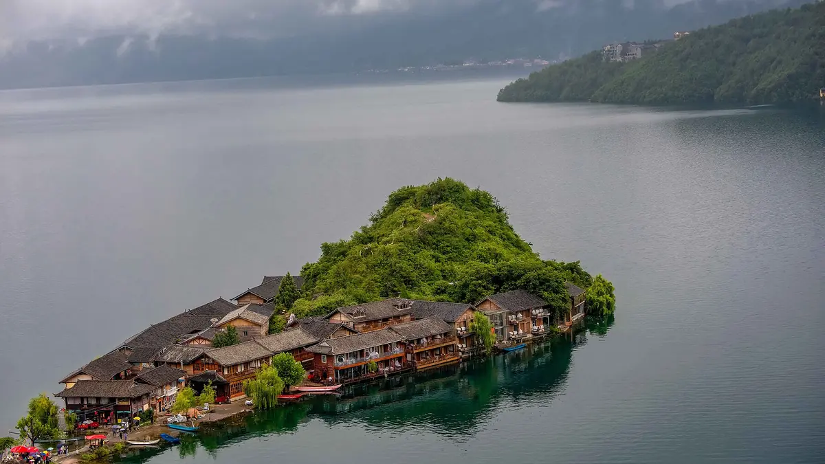 Small wooded island with clustered buildings surrounded by calm lake water