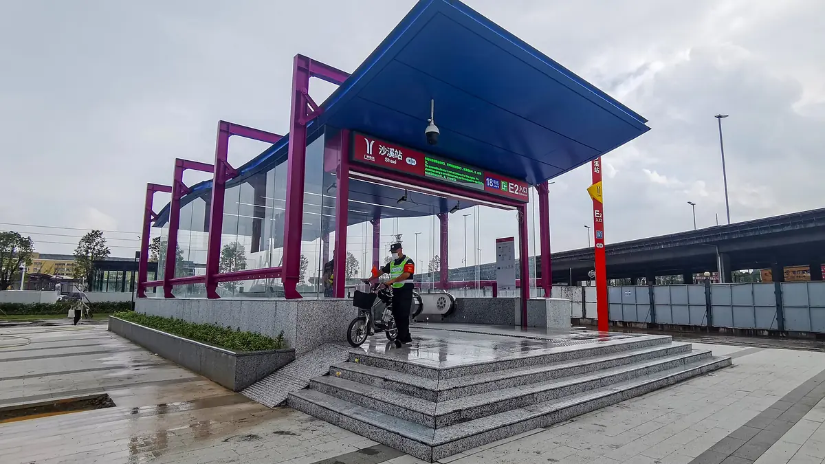 Teduhan stesen keluli merah dan ungu di sisi basikal dan plaza berturap